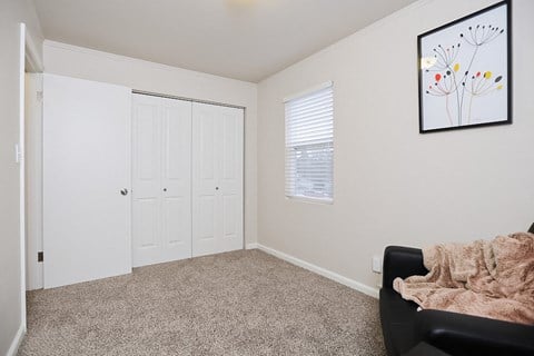 a bright living space with a chair and a door to a closet